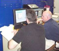 Two men performing computer operations