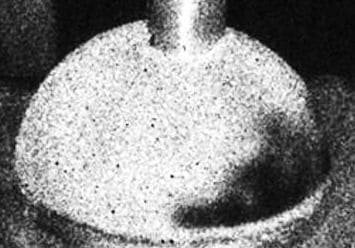 a hemispherically shaped medical device test part showing areas of disbonds.